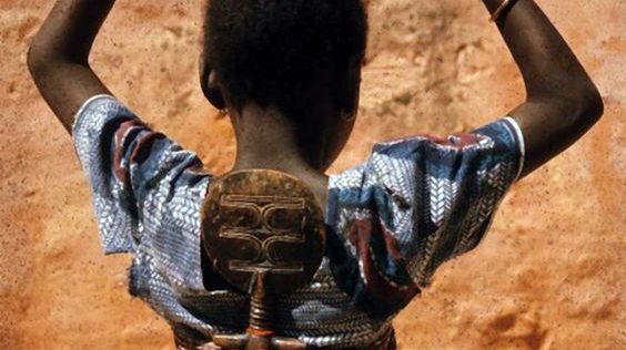 Niño con muñeca en la espalda Niño con muñeca en la espalda