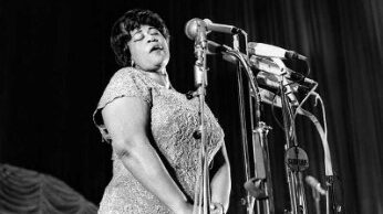 Apodada "La Primera Dama de la Canción", Ella Fitzgerald fue la cantante de jazz femenina más popular en los Estados Unidos durante más de medio siglo. En su vida, ganó 13 premios Grammy y vendió más de 40 millones de álbumes. Su voz era flexible, amplia, precisa y sin edad. Podía cantar baladas sensuales, jazz dulce e imitar todos los instrumentos de una orquesta. Trabajó con todos los grandes del jazz, desde Duke Ellington, Count Basie y Nat King Cole, hasta Frank Sinatra, Dizzy Gillespie y Benny Goodman. (O más bien, algunos podrían decir que todos los grandes del jazz tuvieron el placer de trabajar con Ella). Actuó en los mejores lugares de todo el mundo y los llenó hasta los topes. Su público era tan diverso como su rango vocal. Eran ricos y pobres, compuestos de todas las razas, todas las religiones y todas las nacionalidades. De hecho, muchos de ellos solo tenían un factor vinculante en común: todos la amaban.