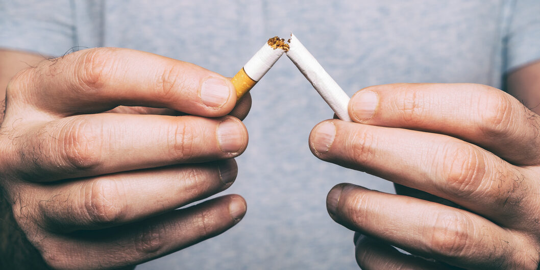 Quitting smoking – male hand crushing cigarette